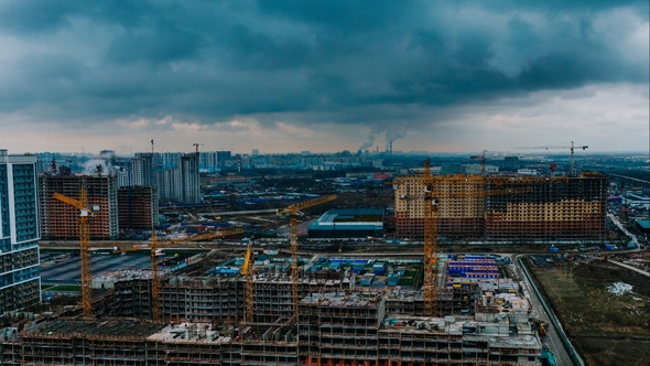 Construction Site Against the Backdrop of the Cityscape, Cranes and Builders Are Working
