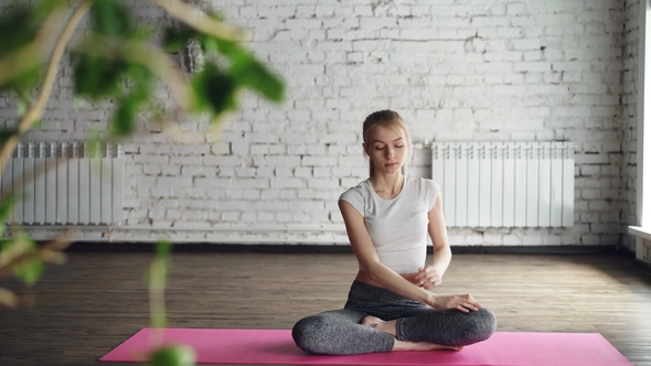 Attractive Slim Blonde Is Practicing Yoga Doing Twist Poses, Bending To Side Then Relaxing in Lotus