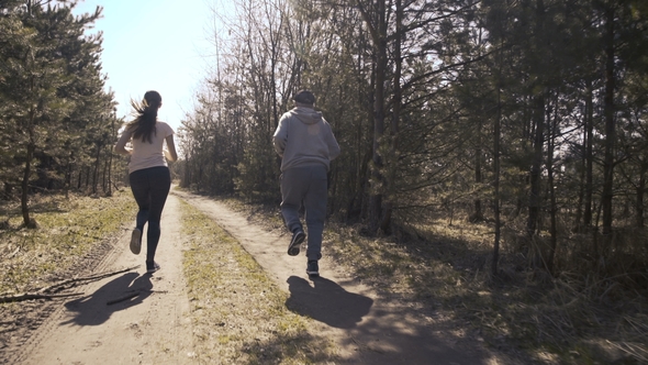 Happy Father and Daughter Jogging in the Early Forest.