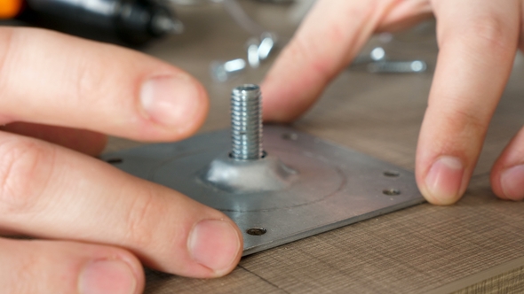 Man Assembling Furniture with an Electric Screwdriver