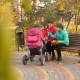 Mom and Daughter Are Sitting on Bench in an Autumn Park with Stroller and Talking - VideoHive Item for Sale