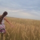 Teenager Girl Spreads Her Arms Like Wings and Walks Across Field - VideoHive Item for Sale