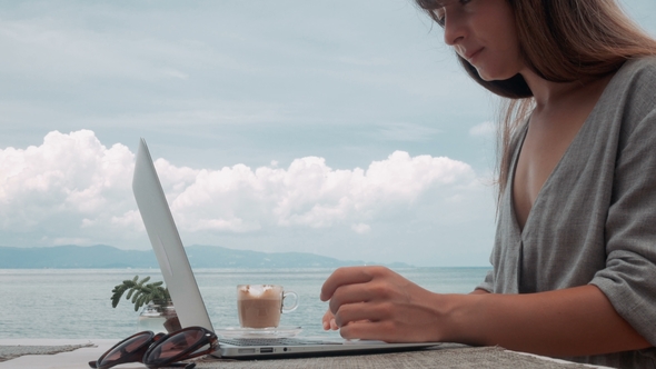 Young Woman Works on Laptop in Outdoor Cafe