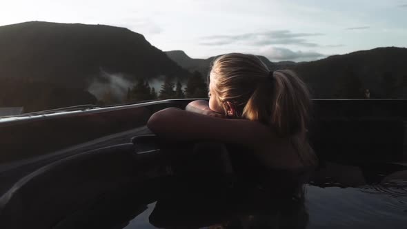 Woman In Hot Tub Relaxing At Sunset