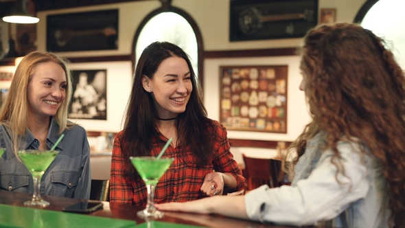 Cheerful Female Friends Socializing in Fancy Bar