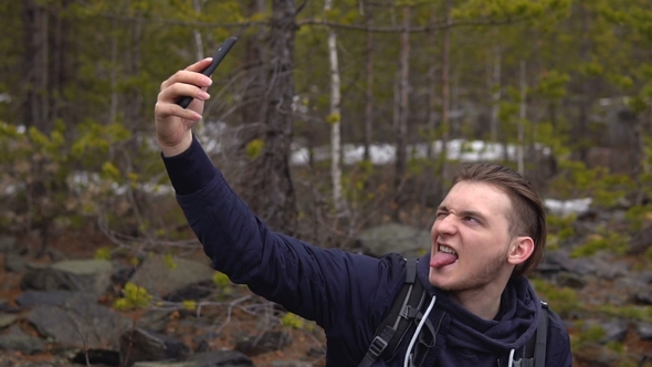 The Tourist Photographs Himself on a Mobile Phone in the Forest