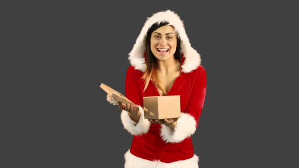 Sexy girl in santa costume opening a gift
