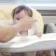 Kid Eats Porridge from Spoon Sitting on Highchair in Kitchen - VideoHive Item for Sale