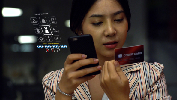 Asian Teenage Girl Using a Mobile Phone to Buy Online Products