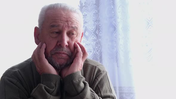 An Elderly Grayhaired Man Has a Headache