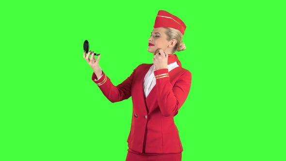 Stewardess Looks in the Mirror and Paints Her Face with a Tassel. Green Screen