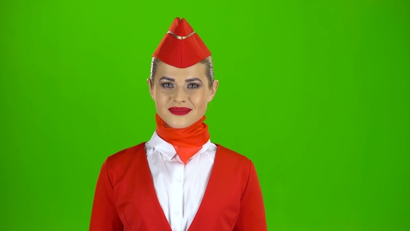 Stewardess in a Red Suit Winks a Slight Flirt. Green Screen