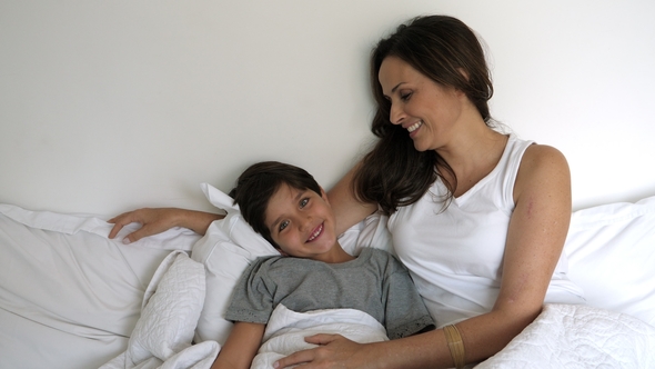 Smiling Mom and Son in Bed