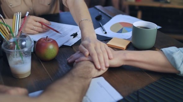Business People Teaming Together Putting Their Hands on Each Other on Table