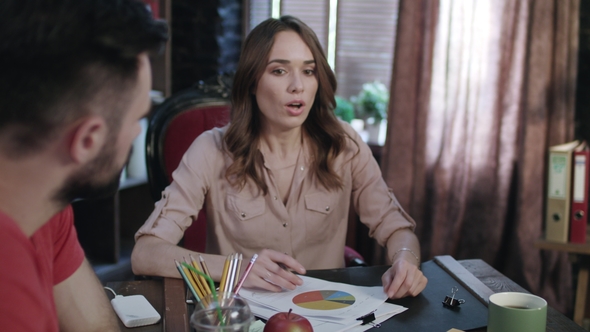 Business Woman Sitting at Erratic Table During Office Meeting with Coworkers