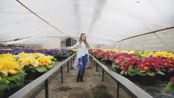 Pretty Young Girl Walks, Poses in Greenhouse and Touches Flower Pots