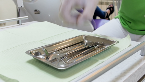 Footage of Dentist Takes Special Instrument for Table While Inspecting Patient's Teeth
