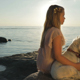 A Sad Little Girl with a Dog is Sitting on the Sea Coast on the Stones - VideoHive Item for Sale