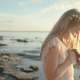 The Girl Watching Down at the Water on the Shore and Turns Her Had - VideoHive Item for Sale