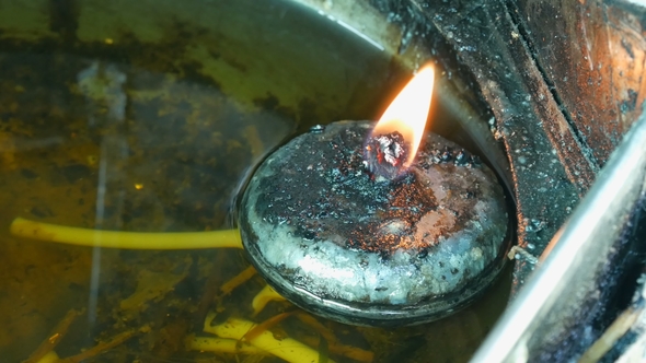 Round Iron Candle with Eternal Fire in Special House. Buddhist Offering To the Gods in the Form of