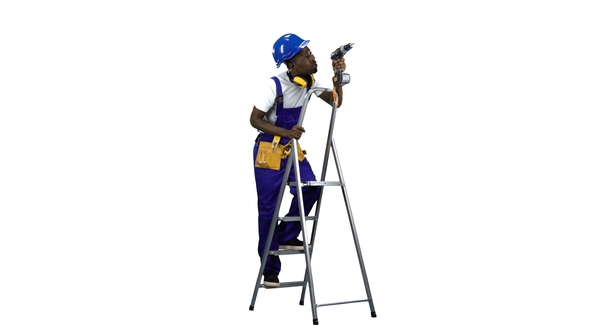 Builder in a Helmet with a Drill in His Hands Climbs the Stairs . Alpha Channel