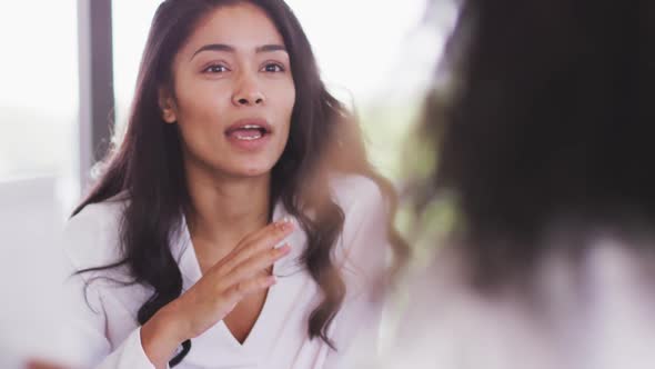 Professional businesswoman talking to her colleagues while sitting in modern office in slow motion