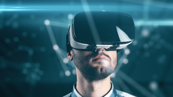 A Young Man with a Beard in Glasses of Virtual Reality on a Technological Background alt