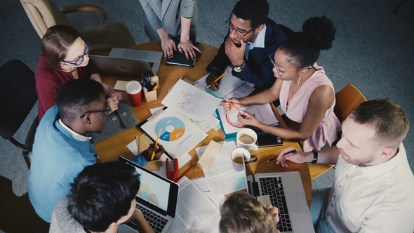 Top View Woman Boss Leading Team Office Meeting. Mixed Ethnicity Colleagues Look at Market Research