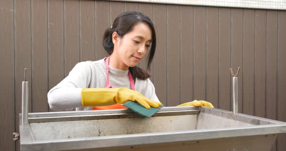 Woman cleaning of barbecue oven