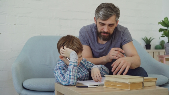 Careful Father Middle-aged Bearded Man Is Helping His Son Concentrated Boy with School Homework