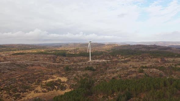 One wind turbine producing electricity in Lindesnes windfarm Norway - Aerial showing turbine operate