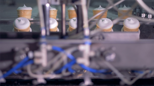 Rows of Wafer Cups with Ice-cream Are Getting Inserted Into Industrial Machine and Then Lifted