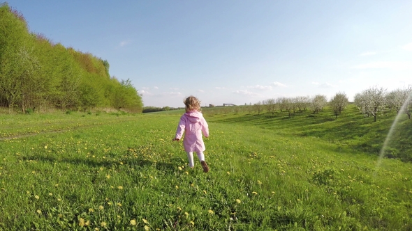 Little Girl Laughing and Running in Garden at Sunset