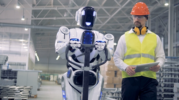 Cyborg Is Moving a Transporting Tool Along the Factory Unit While Being Regulated By a Male Worker