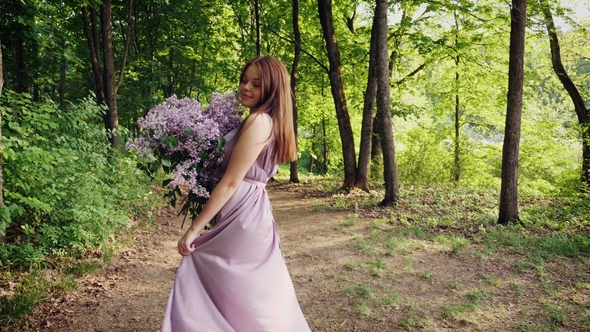 Woman Is Enjoying the Scent of Lilac