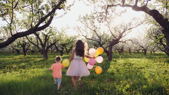 Children Running in a Blooming Garden at Sunset