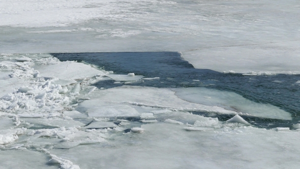 Cracked Ice Floating on the River in Spring Time