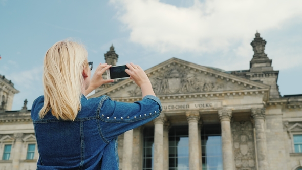A Woman Tourist Takes Pictures of the Building of the Bundestag in Berlin. Tourism in Germany and