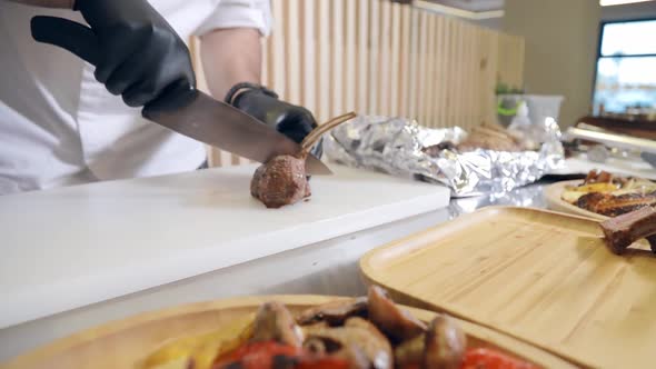 The Cook Cuts Pieces of Finished Freshly Baked Lamb