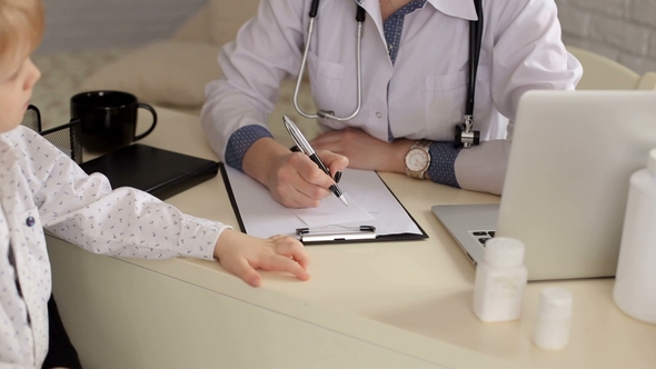 Doctor's Hand with a Pen While Taking a Child. CU