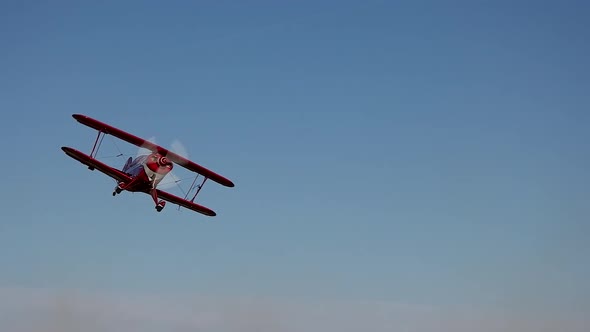 Aerobatic Pitts S2B biplane performs a turn away from the camera during a low pass.