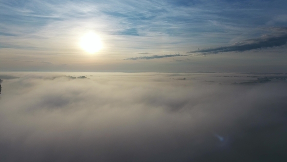 Flight From Above Over Dense Fog at Dawn