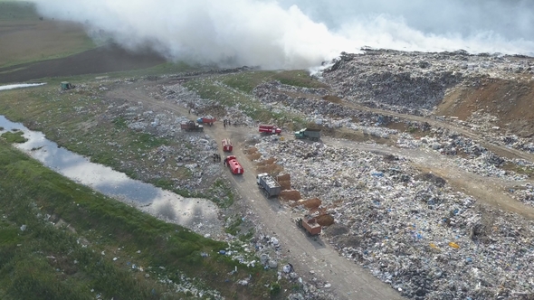 Garbage Dump Pollutes the Environment. Strong Wind Rises Toxic Smoke of Burning Garbage Into the Air