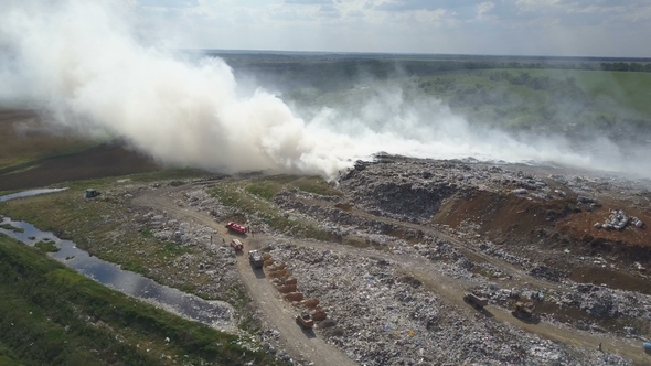 Garbage Dump Pollutes the Environment. Strong Wind Rises Toxic Smoke of Burning Garbage Into the Air