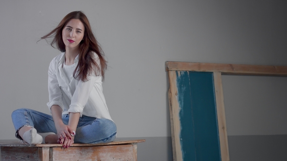 Woman in Industrial Studio Wears Jeans and White Shirt