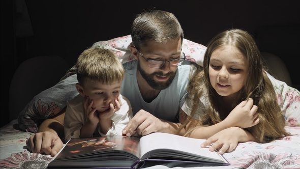 Loving Father Reads a Fairy Tale for Children Overnight