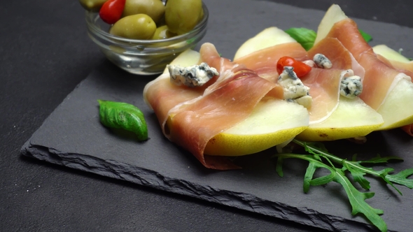 Sliced Prosciutto and Melon on a Stone Board