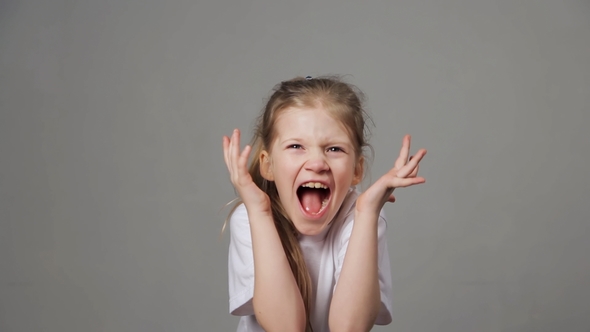 Pretty Young Girl Shouting on Grey Background. Screaming Child