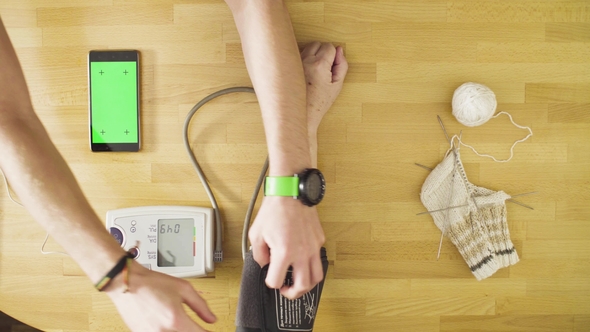 Young Man Measuring Blood Pressure of Senior Woman