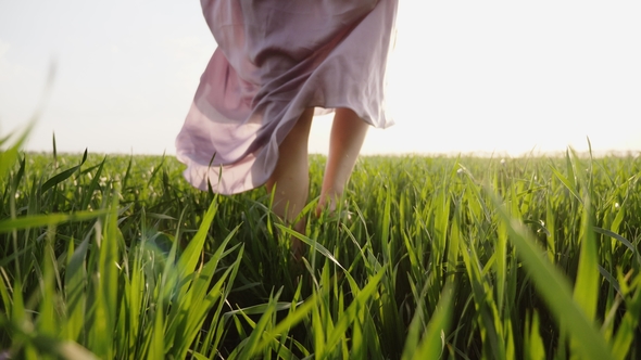 Woman in Pink Dress Walks Barefoot on Grass